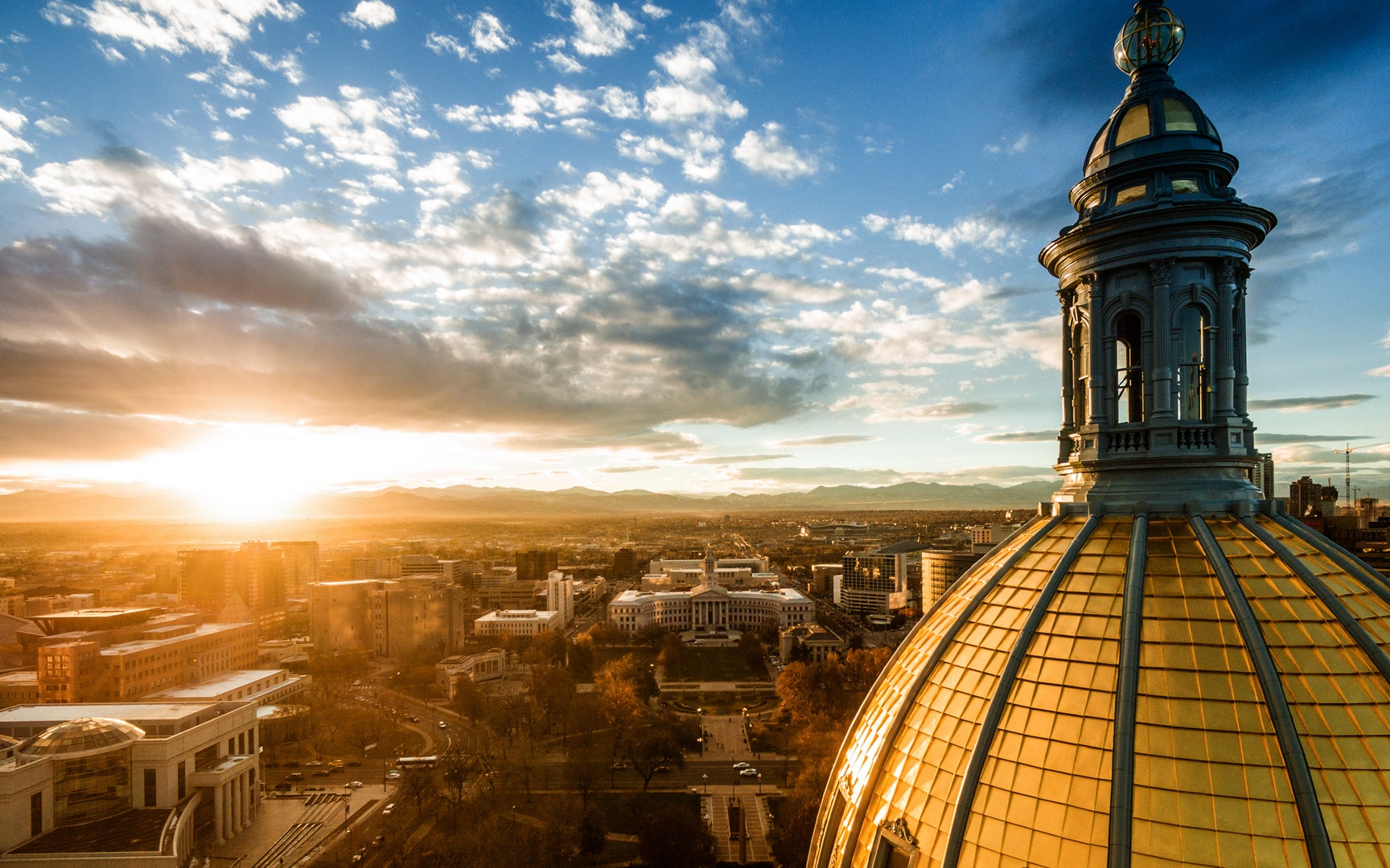 Sunset photo of Colorado capital building and city of Denver skyline.