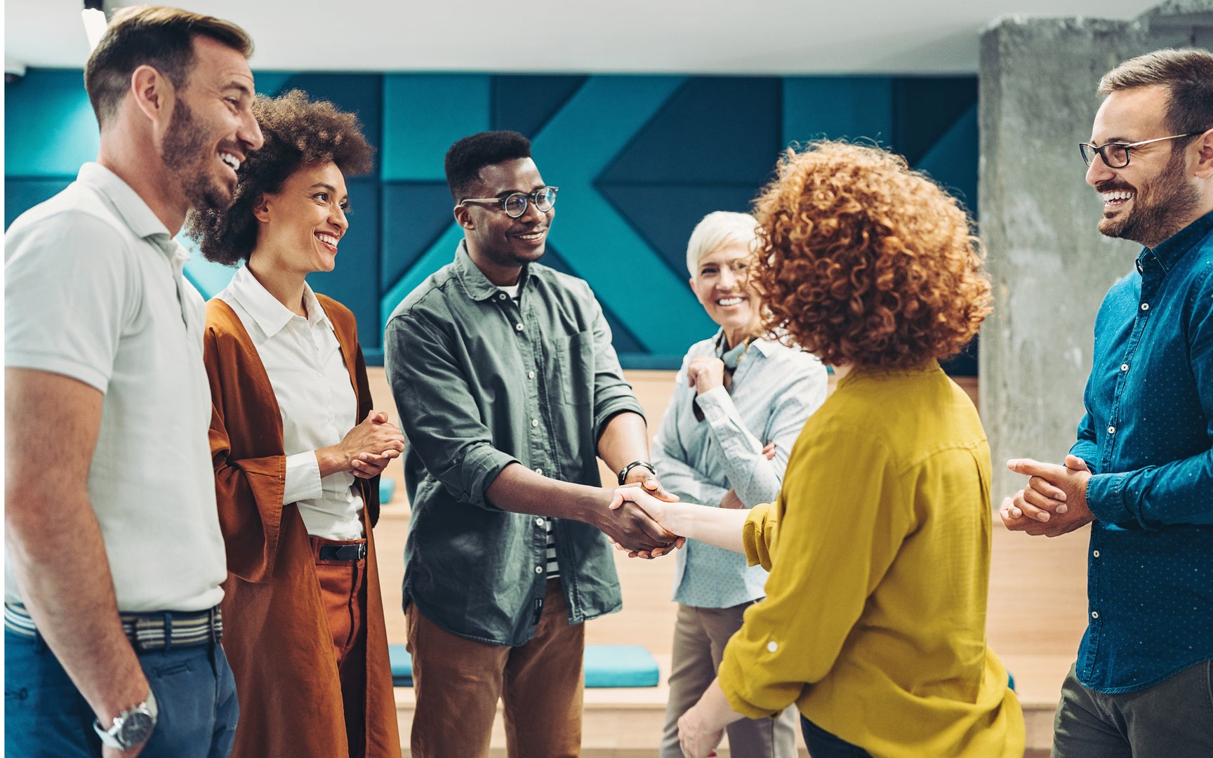 Smiling, diverse business persons shaking hands.