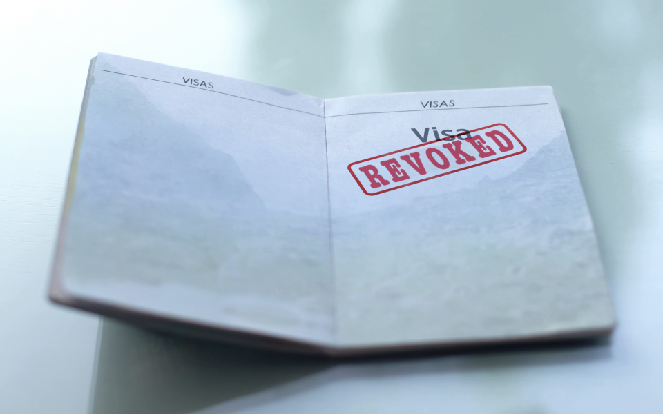 Open Visa booklet with the workd "Revoked" stamped on it.