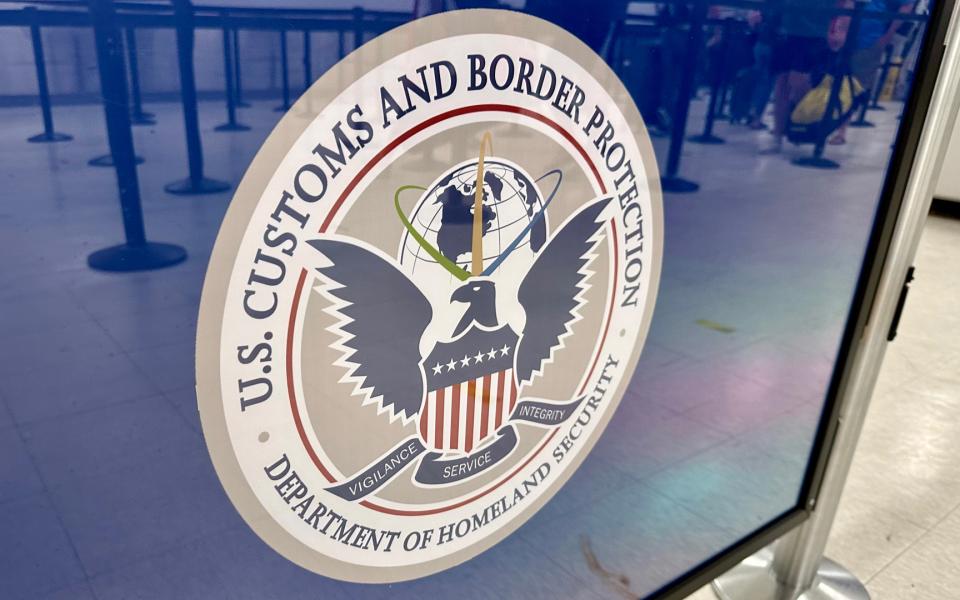 U.S Customs and Border Protection logo on a queue barrier.