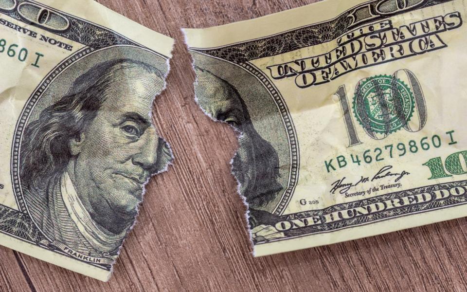 Close up of a dollar bill torn in half.