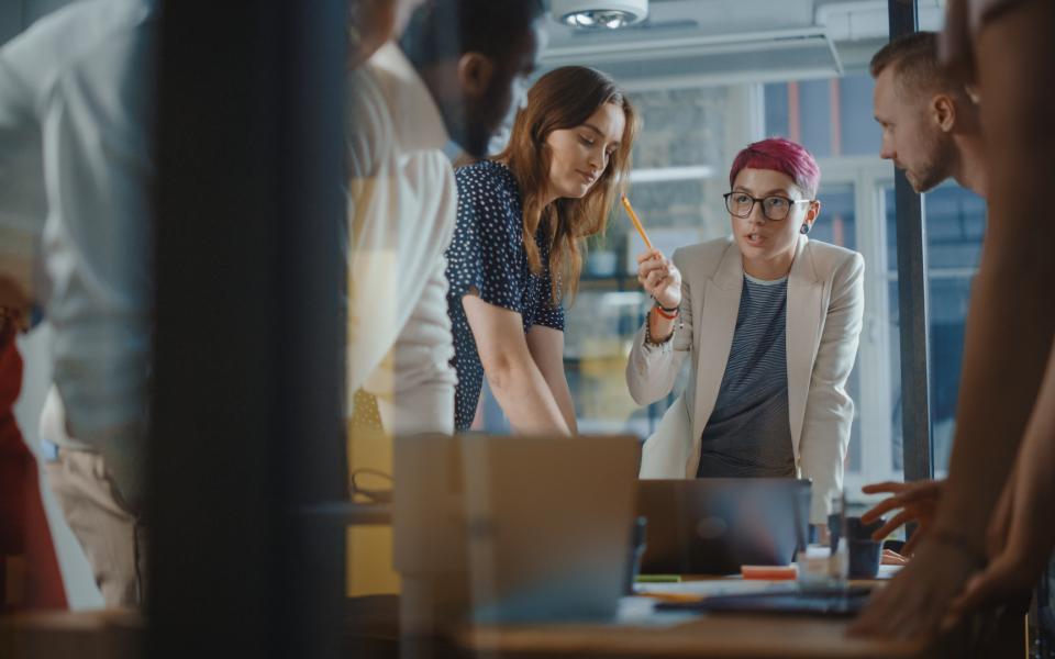 A group of diverse young professionals meeting in a conference room.