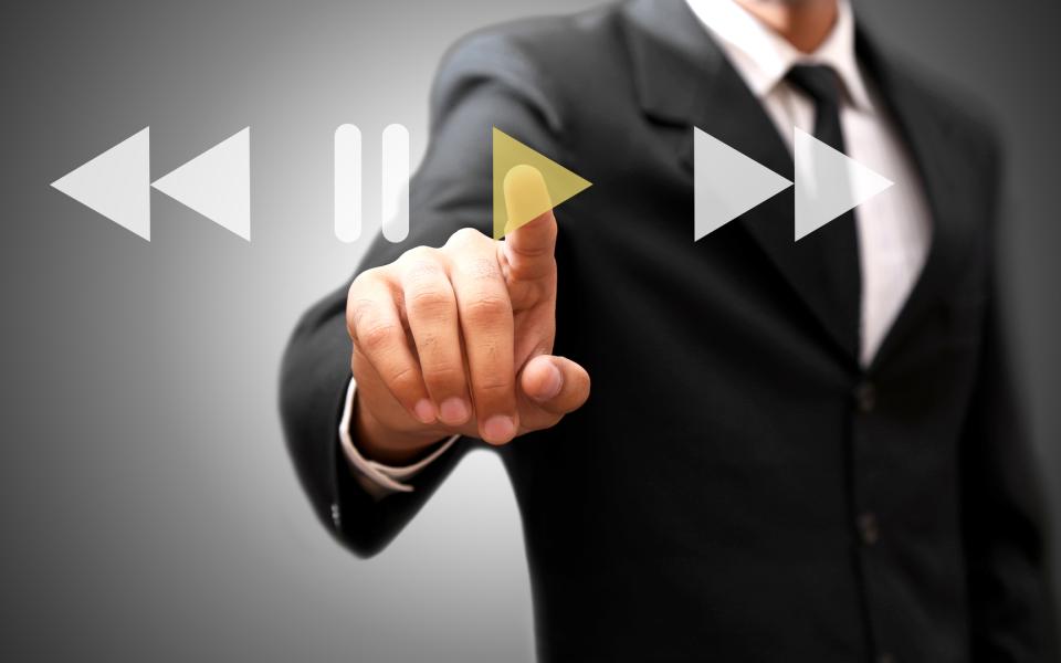 Close-up of a man's finger pressing the play button on a virtual touch screen.